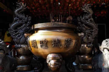 Large Taoist incense burner with intricate dragon and lion statues at a temple