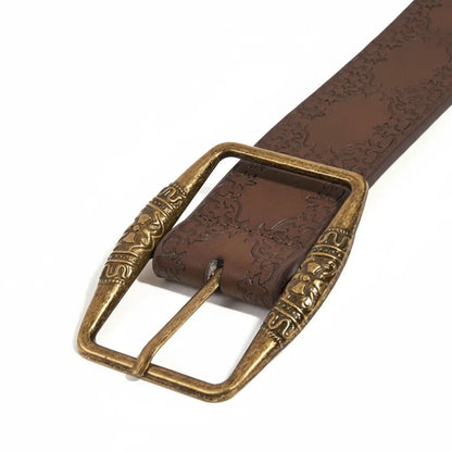 Close-up of antique brass buckle on women’s vintage embossed leather belt